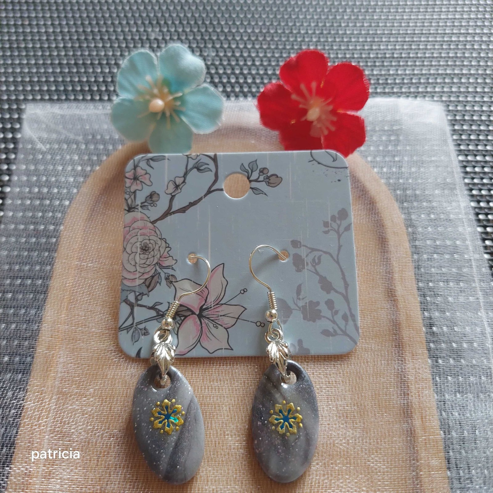Boucles d'oreilles florales grises.